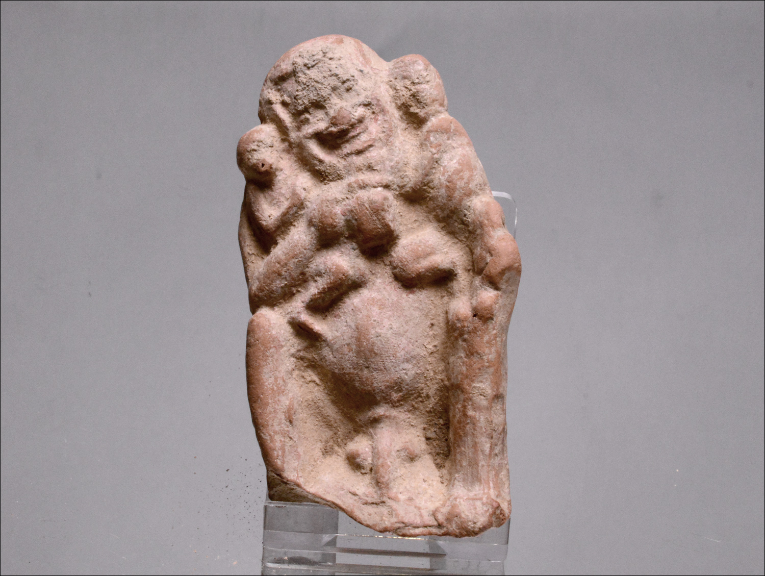 Roman terracotta of naked actor holding two monkeys,.